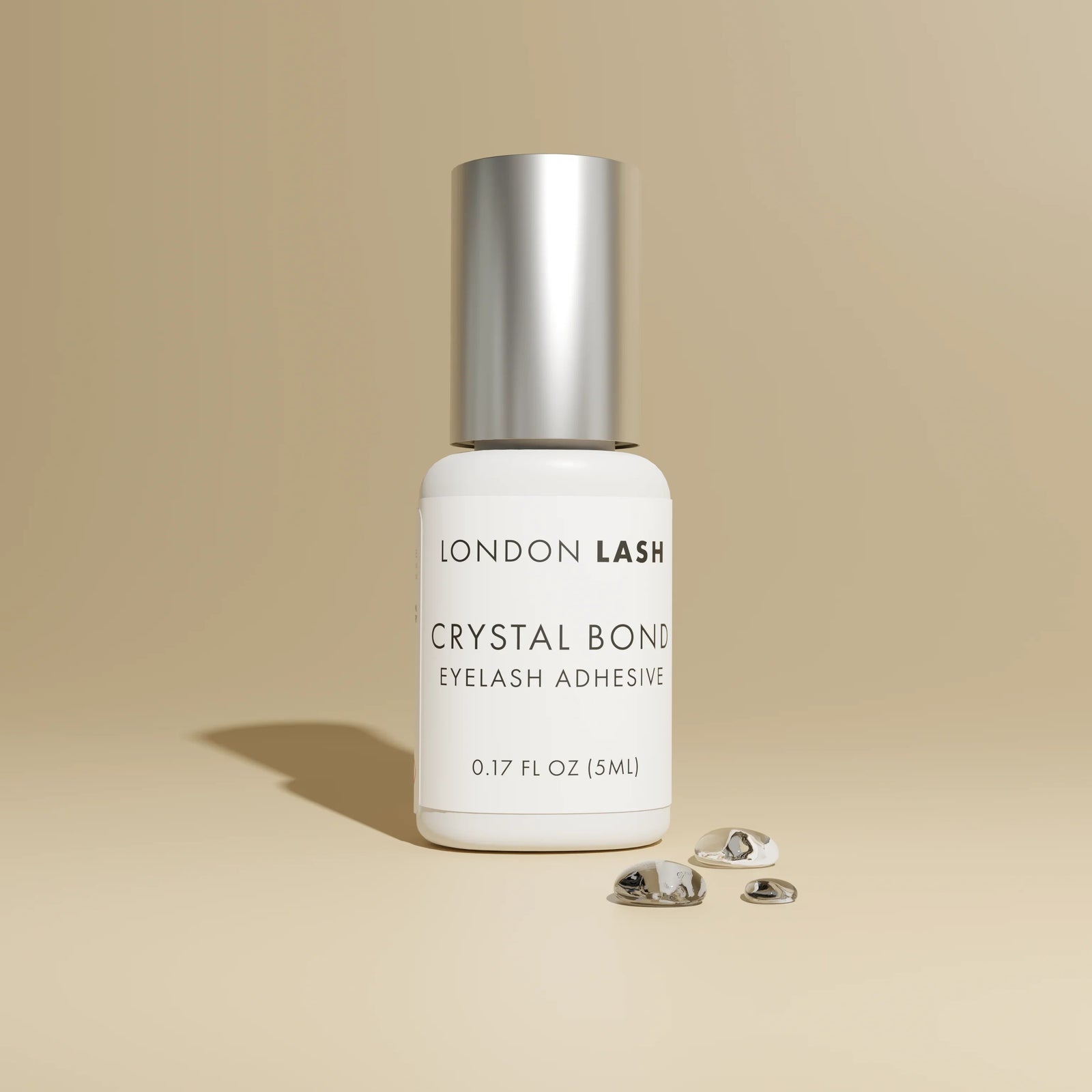 London Lash Glue Subscription - Crystal Bond Eyelash Adhesive bottle on beige background