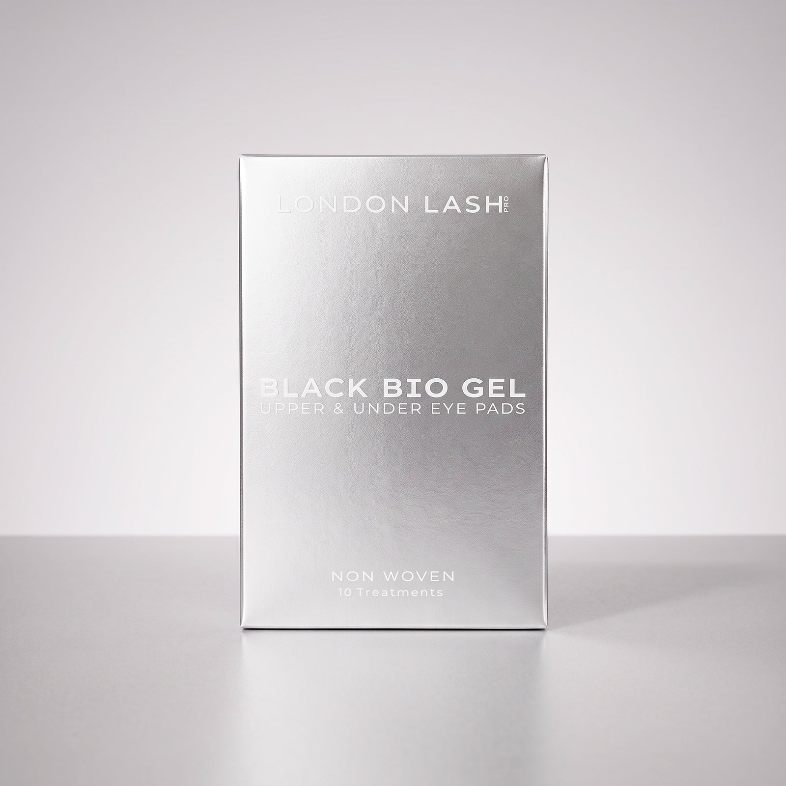 Vista en perspectiva de la caja plateada de los parches negros de biogel para párpados superiores y contorno de ojos de London Lash, con 10 tratamientos.