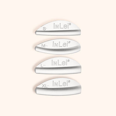 InLei® ONLY rizadores de pestañas de silicona dispuestos en fila sobre fondo neutro para destacar sus tamaños.